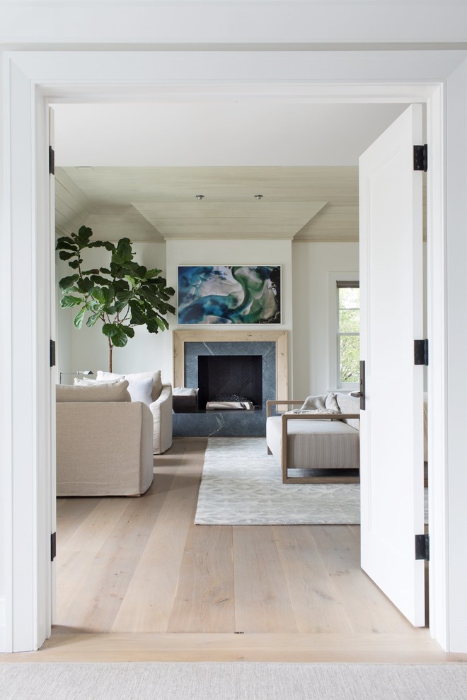 Идея дизайна: изолированная гостиная комната среднего размера в стиле неоклассика (современная классика) с белыми стенами, паркетным полом среднего тона, стандартным камином, фасадом камина из дерева, скрытым телевизором и коричневым полом
