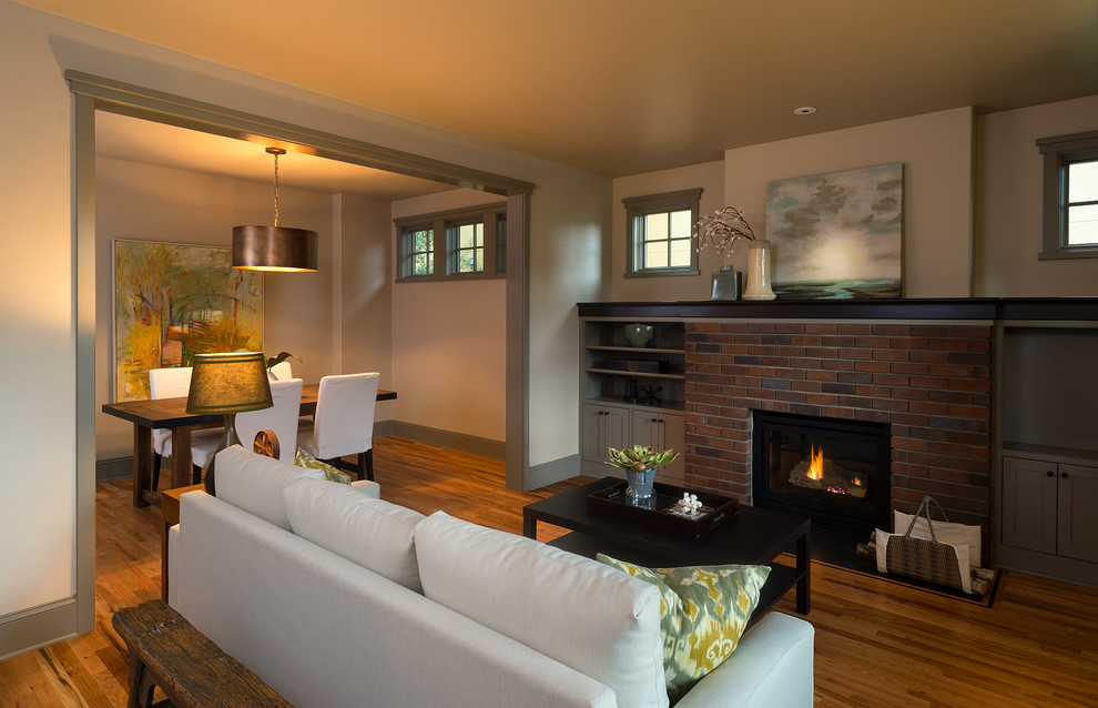 Aménagement d'un salon contemporain avec un mur beige, un sol en bois brun, une cheminée standard et un manteau de cheminée en brique.