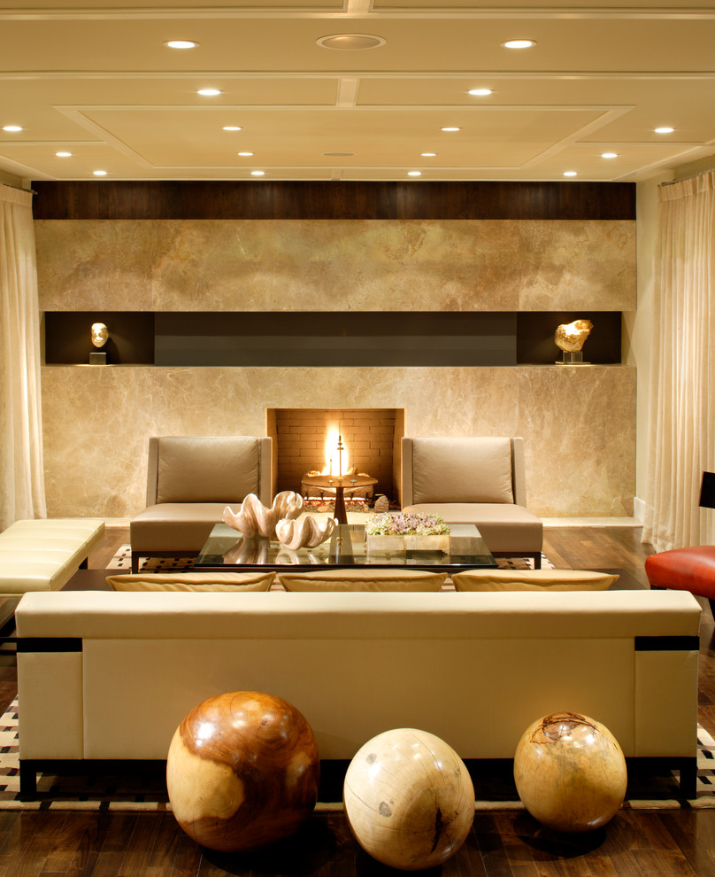 Immagine di un grande soggiorno minimal aperto con pareti beige, camino classico e parquet scuro