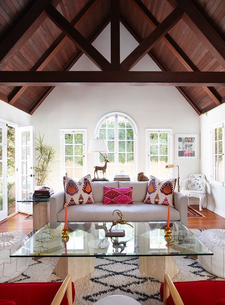 Immagine di un soggiorno classico aperto con sala formale, pareti bianche, pavimento in legno massello medio e nessun camino
