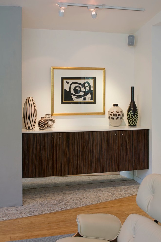 Esempio di un soggiorno moderno con pareti grigie, pavimento in bambù, camino classico, cornice del camino in intonaco e TV a parete