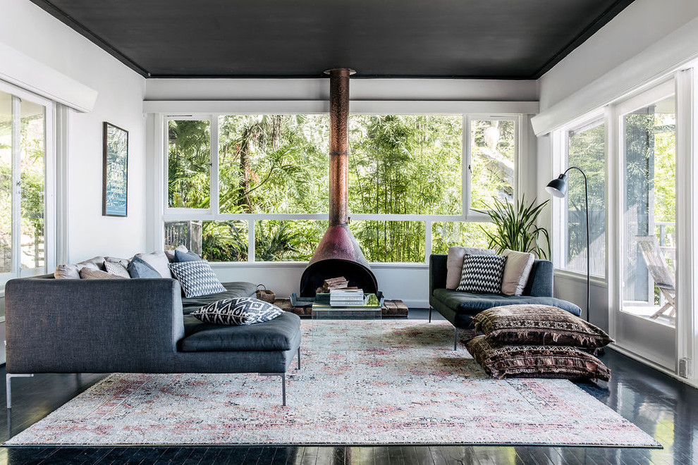 Idee per un soggiorno contemporaneo con pareti bianche, pavimento in legno verniciato, stufa a legna e pavimento nero