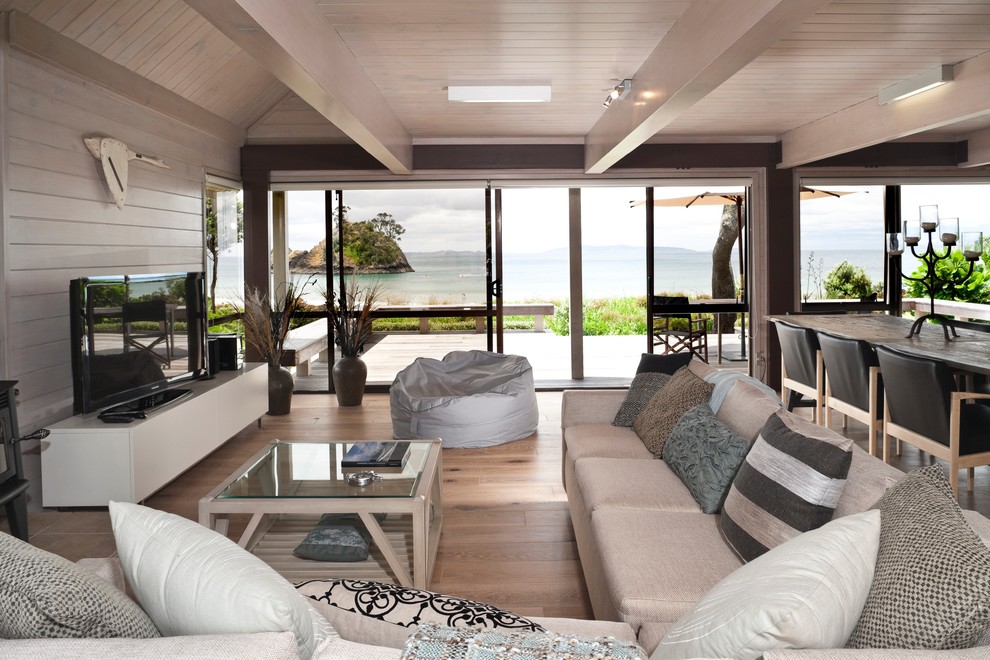Mittelgroßes, Offenes Maritimes Wohnzimmer mit weißer Wandfarbe und freistehendem TV in Auckland