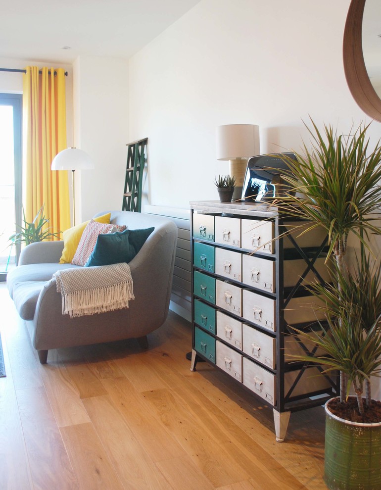 Mittelgroßes, Repräsentatives, Offenes Industrial Wohnzimmer mit weißer Wandfarbe, braunem Holzboden und freistehendem TV in Wiltshire