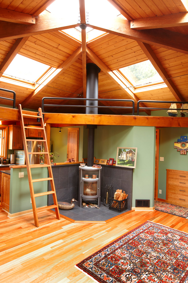 Источник вдохновения для домашнего уюта: гостиная комната в стиле рустика с зелеными стенами, паркетным полом среднего тона и печью-буржуйкой