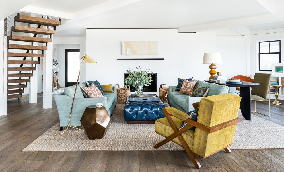 Example of a beach style open concept medium tone wood floor living room design in Seattle with white walls, a standard fireplace and a plaster fireplace