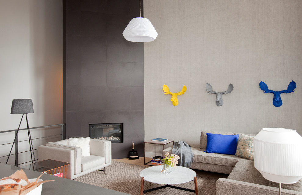 Стильный дизайн: большая открытая гостиная комната в современном стиле с серыми стенами, светлым паркетным полом, угловым камином и фасадом камина из плитки без телевизора - последний тренд