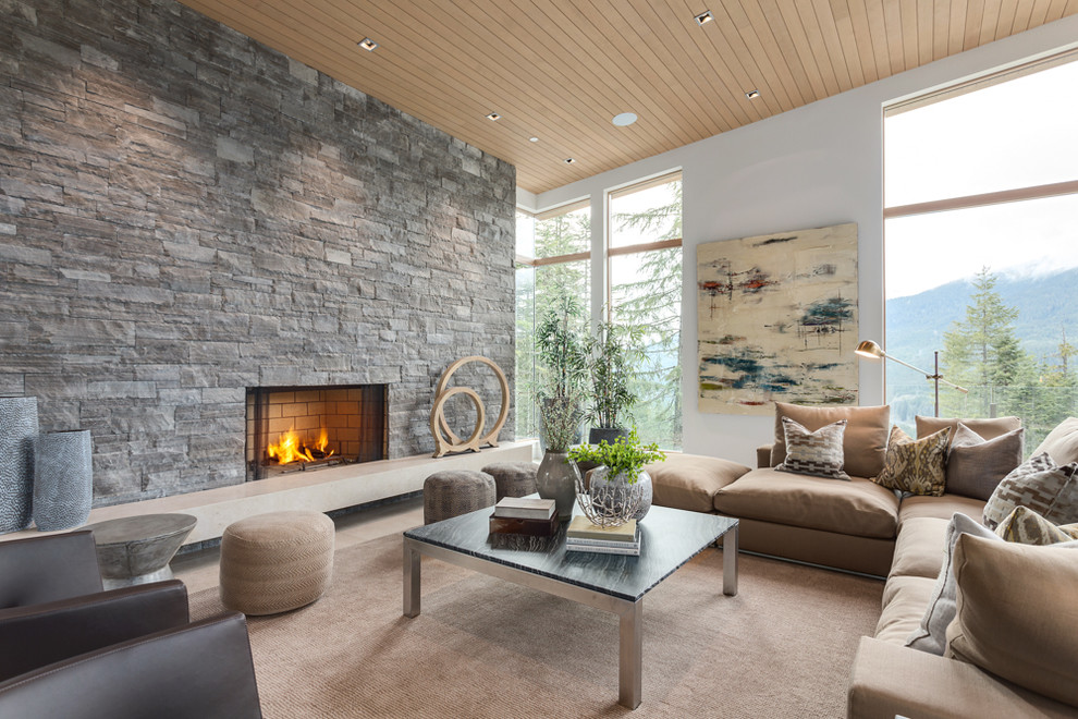 Modernes Wohnzimmer mit gelber Wandfarbe, Kamin und Kaminumrandung aus Stein in Vancouver