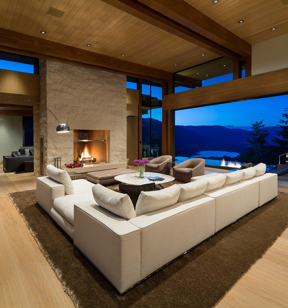 Design ideas for an expansive contemporary formal open plan living room in Vancouver with beige walls, light hardwood flooring, a standard fireplace, a stone fireplace surround and no tv.