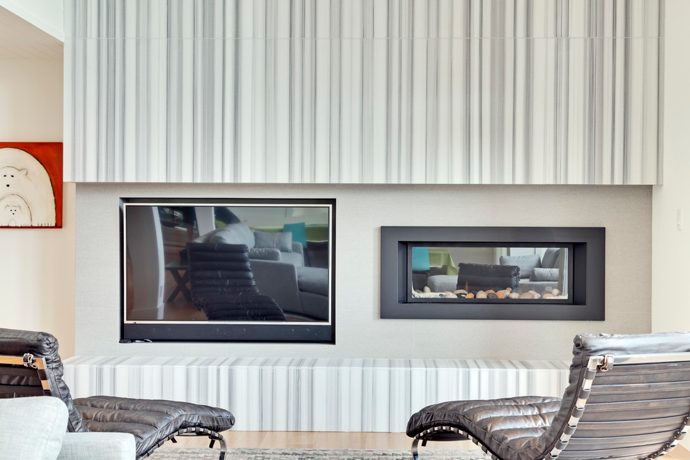 Пример оригинального дизайна: большая открытая гостиная комната в современном стиле с серыми стенами, светлым паркетным полом, стандартным камином и телевизором на стене