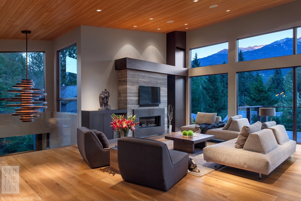 Large contemporary formal open plan living room in Vancouver with grey walls, medium hardwood flooring, a hanging fireplace, a stone fireplace surround, no tv and brown floors.