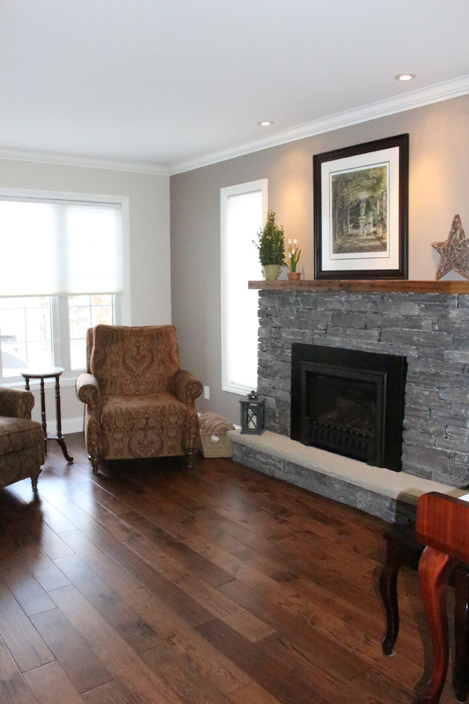 Design ideas for a medium sized traditional living room in Toronto with grey walls, dark hardwood flooring, a standard fireplace and a stone fireplace surround.