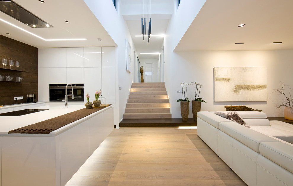 Idee per un grande soggiorno moderno aperto con sala formale, pareti bianche, pavimento in legno massello medio, TV a parete e pavimento beige