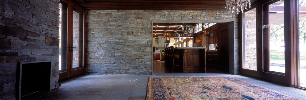 Esempio di un soggiorno design aperto con camino classico e cornice del camino in pietra