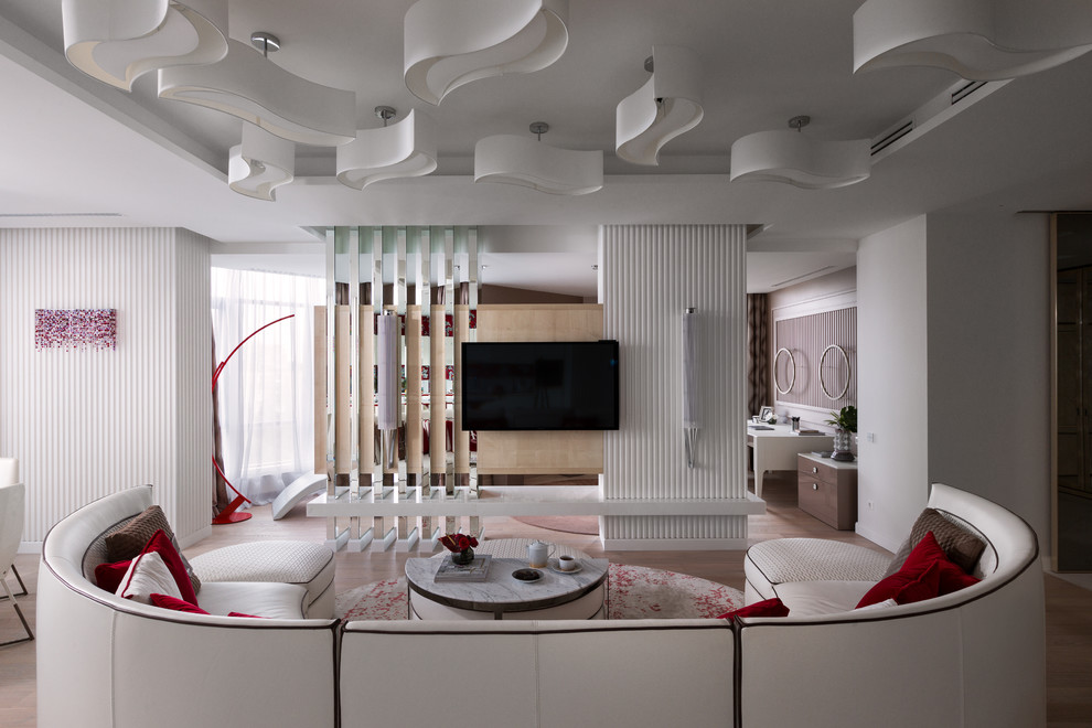Offenes Modernes Wohnzimmer mit weißer Wandfarbe, hellem Holzboden, TV-Wand und beigem Boden in Sonstige