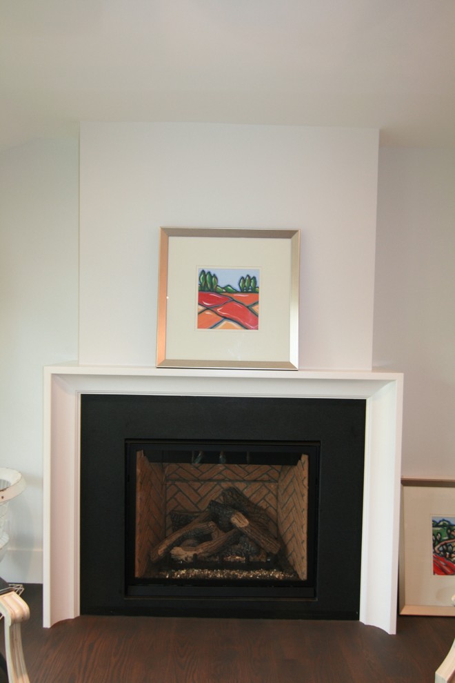 Cette image montre un petit salon design ouvert avec un mur blanc, parquet foncé, une cheminée standard et un manteau de cheminée en bois.