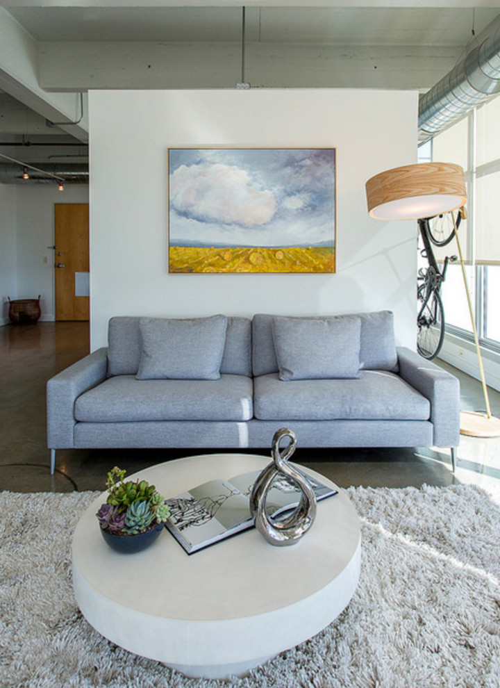 Cette image montre un salon minimaliste de taille moyenne et ouvert avec sol en béton ciré, un mur blanc, aucune cheminée, un téléviseur indépendant, un sol gris et éclairage.