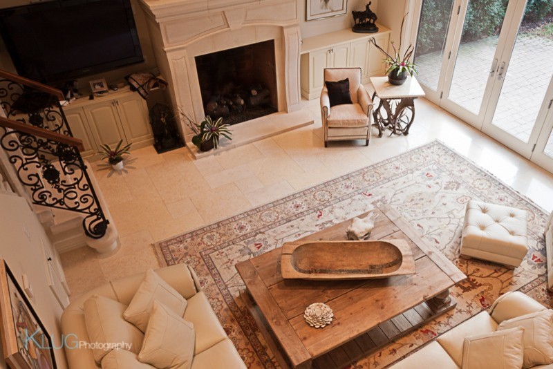 Cette photo montre un grand salon chic avec une salle de réception, un mur beige, un sol en marbre, une cheminée standard, un manteau de cheminée en carrelage et un téléviseur d'angle.