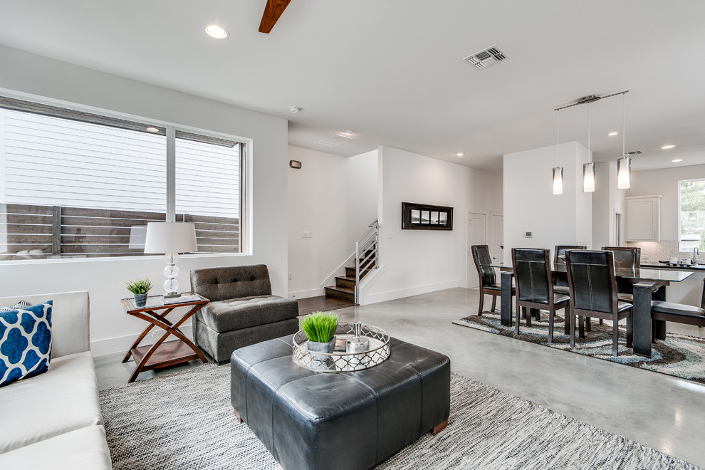 Esempio di un soggiorno minimalista con pareti bianche, pavimento in cemento e pavimento grigio