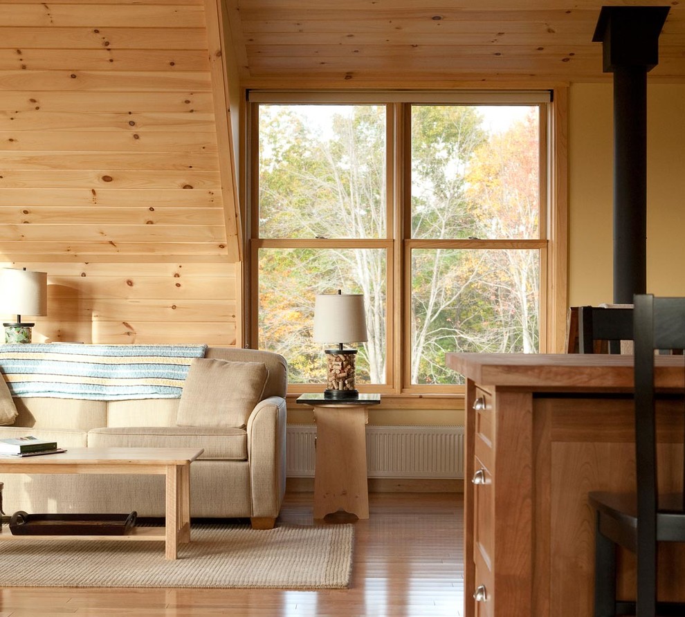 Immagine di un soggiorno country di medie dimensioni e aperto con libreria, pareti beige e parquet chiaro