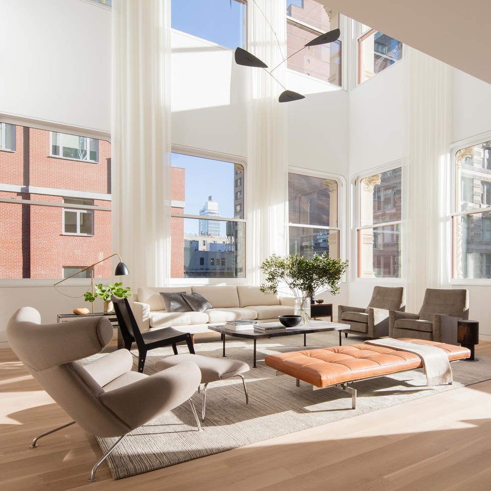 Modernes Wohnzimmer mit hellem Holzboden und weißem Boden in New York