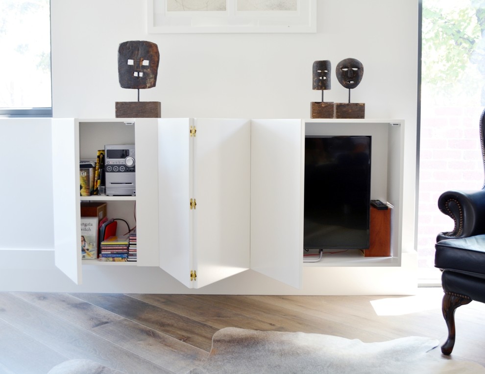 Inspiration för små moderna vardagsrum, med vita väggar, mellanmörkt trägolv och en dold TV