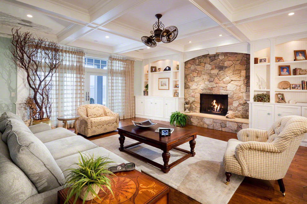 Photo of a traditional living room curtain in New York with green walls, a standard fireplace, a stone fireplace surround and medium hardwood flooring.