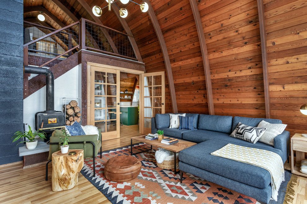Idee per un soggiorno rustico aperto con sala formale, pareti marroni, pavimento in legno massello medio, stufa a legna, nessuna TV e pavimento marrone