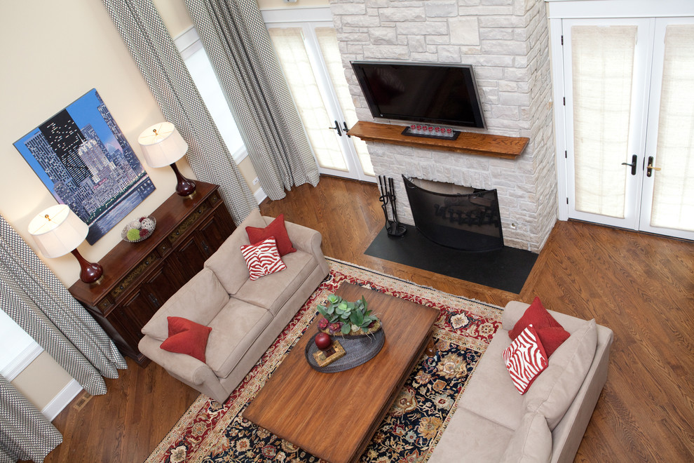 Repräsentatives Klassisches Wohnzimmer im Loft-Stil mit beiger Wandfarbe, braunem Holzboden, Kamin, Kaminumrandung aus Stein, TV-Wand und braunem Boden in Chicago