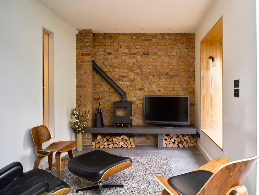 Источник вдохновения для домашнего уюта: маленькая гостиная комната в современном стиле с белыми стенами, отдельно стоящим телевизором, серым полом и печью-буржуйкой для на участке и в саду