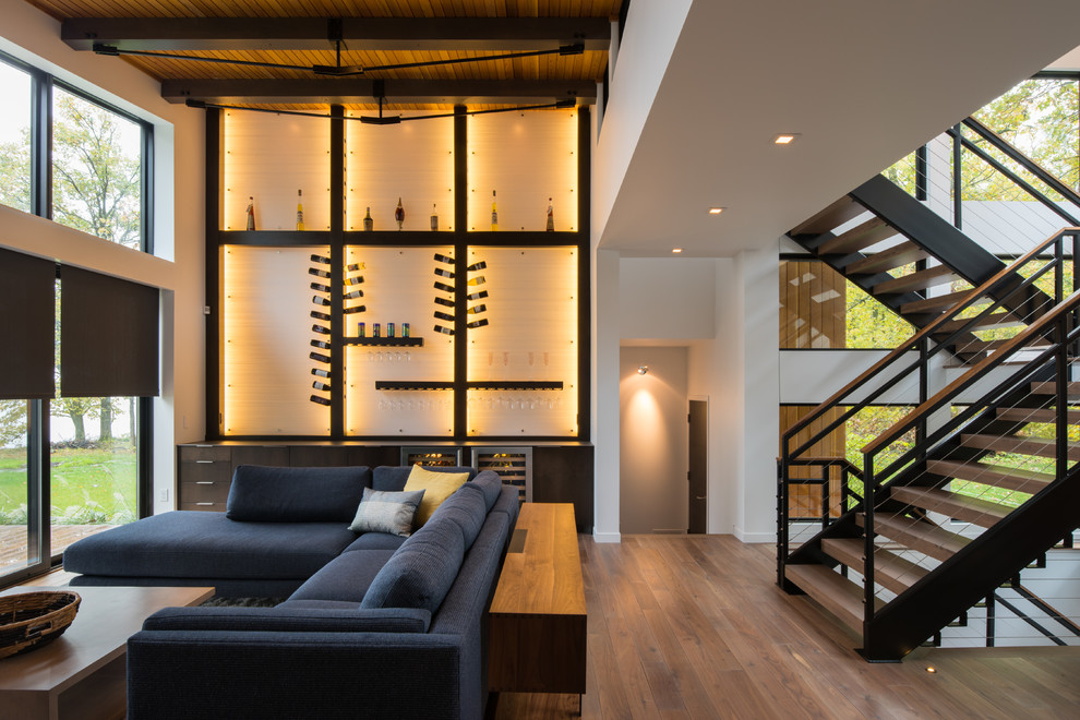Idées déco pour un salon contemporain ouvert avec un mur blanc, un sol en bois brun, un sol marron et un escalier.