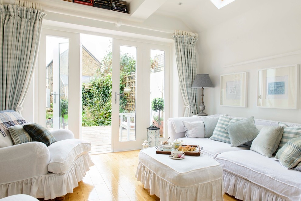 Cette photo montre un petit salon romantique avec un mur blanc, un sol en bois brun et éclairage.