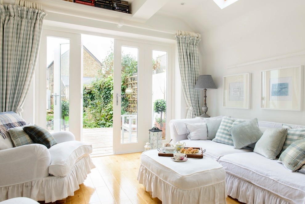 Inspiration for a small shabby-chic style medium tone wood floor living room remodel in Kent with white walls