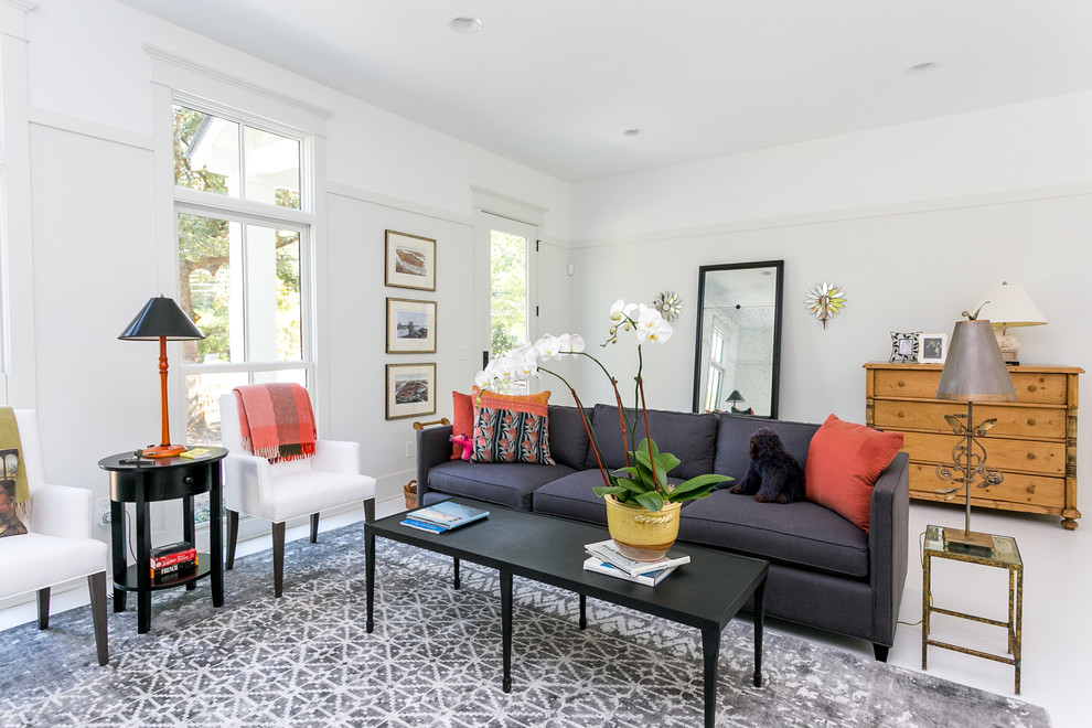 This is an example of a bohemian living room in Raleigh with white walls and white floors.