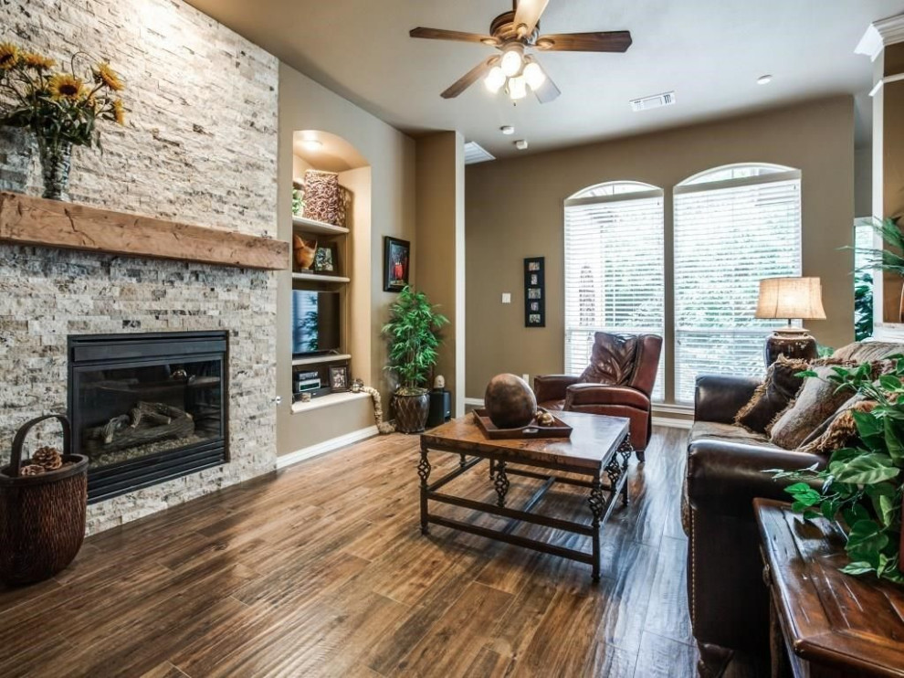 Mid-sized elegant open concept dark wood floor and brown floor living room photo in Dallas with beige walls, a standard fireplace, a stone fireplace and a media wall