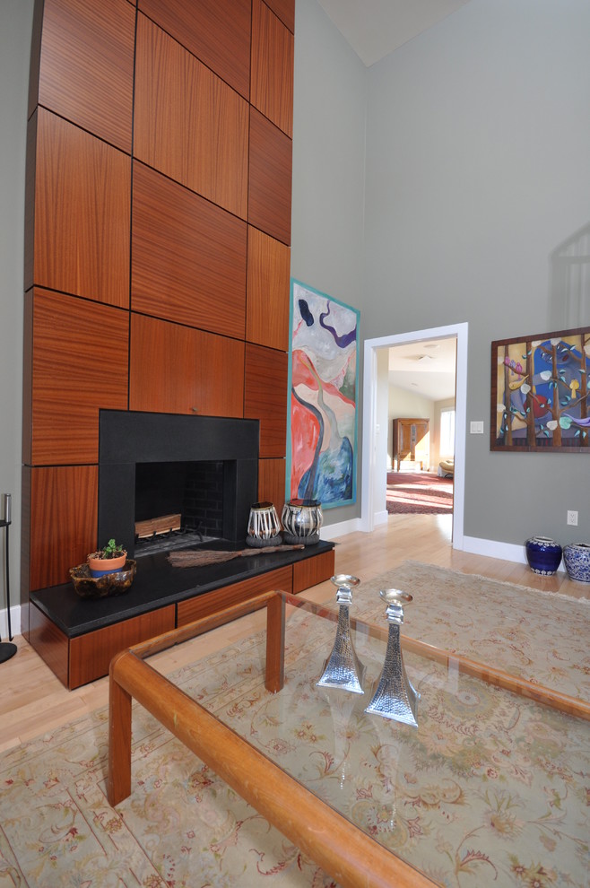 Ejemplo de salón para visitas abierto contemporáneo extra grande sin televisor con paredes grises, suelo de madera clara, estufa de leña y marco de chimenea de piedra
