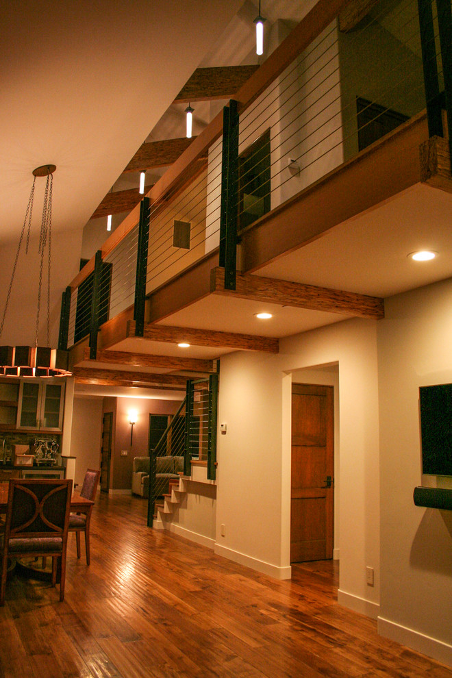 Modelo de salón tipo loft actual de tamaño medio con suelo de madera en tonos medios y televisor colgado en la pared