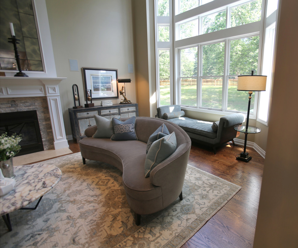 This is an example of a large classic open plan living room in Detroit with beige walls, medium hardwood flooring, a standard fireplace, a stone fireplace surround and brown floors.
