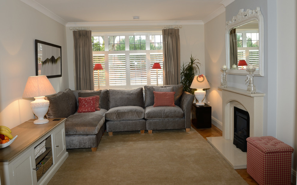 Large traditional enclosed living room in London with beige walls, porcelain flooring, a standard fireplace, a stone fireplace surround and beige floors.