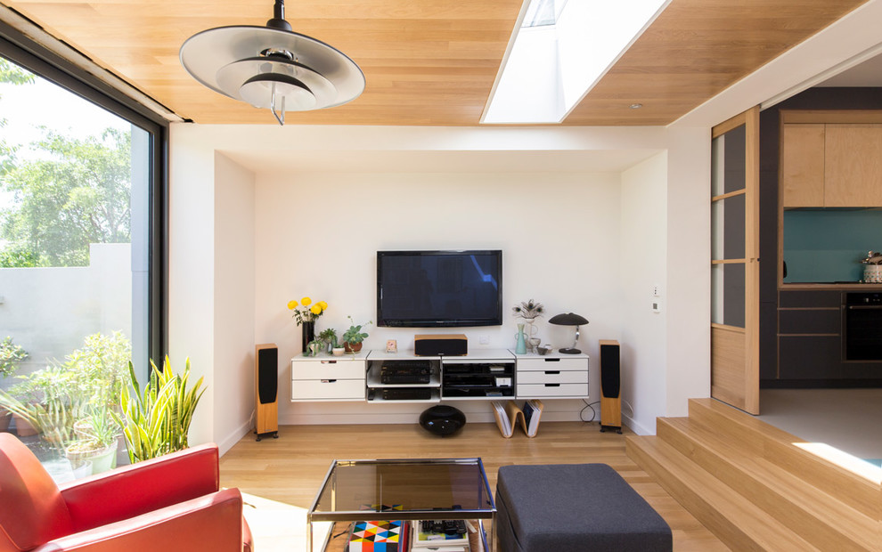 Источник вдохновения для домашнего уюта: изолированная гостиная комната среднего размера в стиле ретро с белыми стенами, светлым паркетным полом, телевизором на стене и бежевым полом без камина