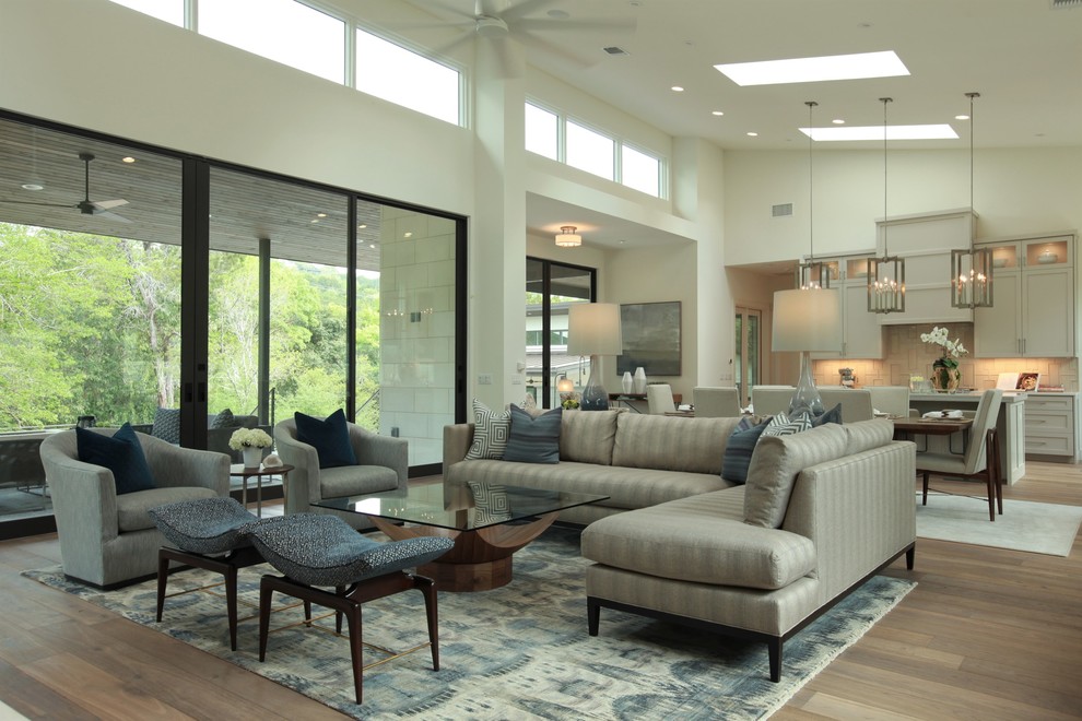 Immagine di un grande soggiorno classico aperto con pareti bianche, pavimento in legno massello medio e TV a parete