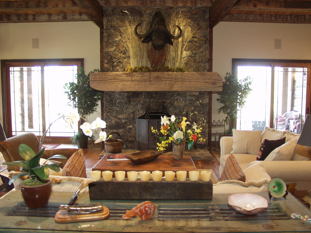 Cette image montre un salon traditionnel avec une cheminée standard et un manteau de cheminée en pierre.