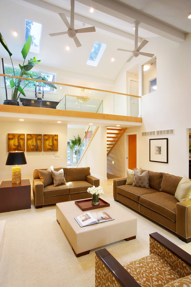 Стильный дизайн: открытая гостиная комната в современном стиле с белыми стенами, ковровым покрытием и коричневым диваном - последний тренд