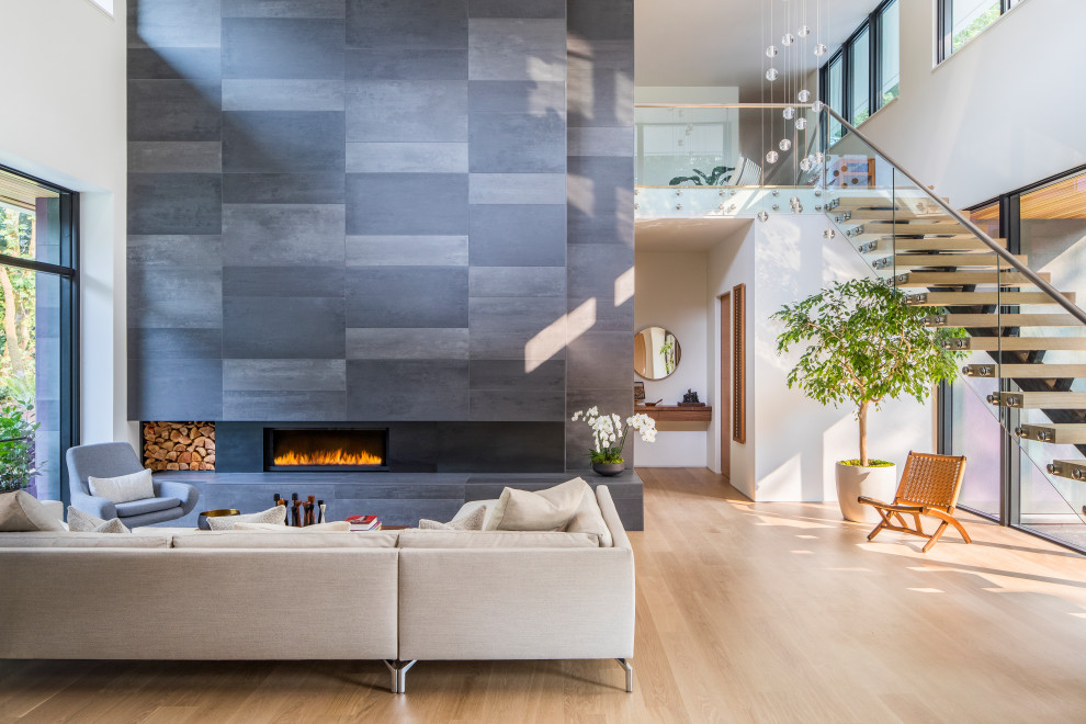 Großes, Offenes Modernes Wohnzimmer mit weißer Wandfarbe, hellem Holzboden, Gaskamin, gefliester Kaminumrandung, beigem Boden und gewölbter Decke in Portland