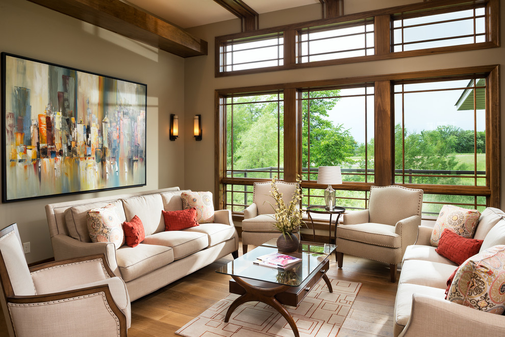 Immagine di un grande soggiorno design aperto con pareti beige, pavimento in legno massello medio e nessuna TV