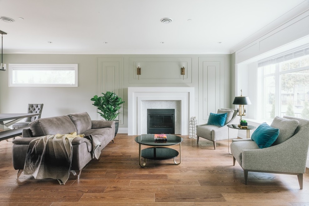 Idée de décoration pour un salon minimaliste ouvert avec une salle de réception, un mur vert, un sol en contreplaqué, une cheminée standard, un manteau de cheminée en pierre et un sol marron.