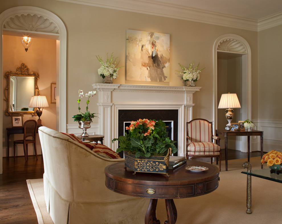 Immagine di un grande soggiorno classico con pareti beige, parquet scuro, camino classico e cornice del camino in legno