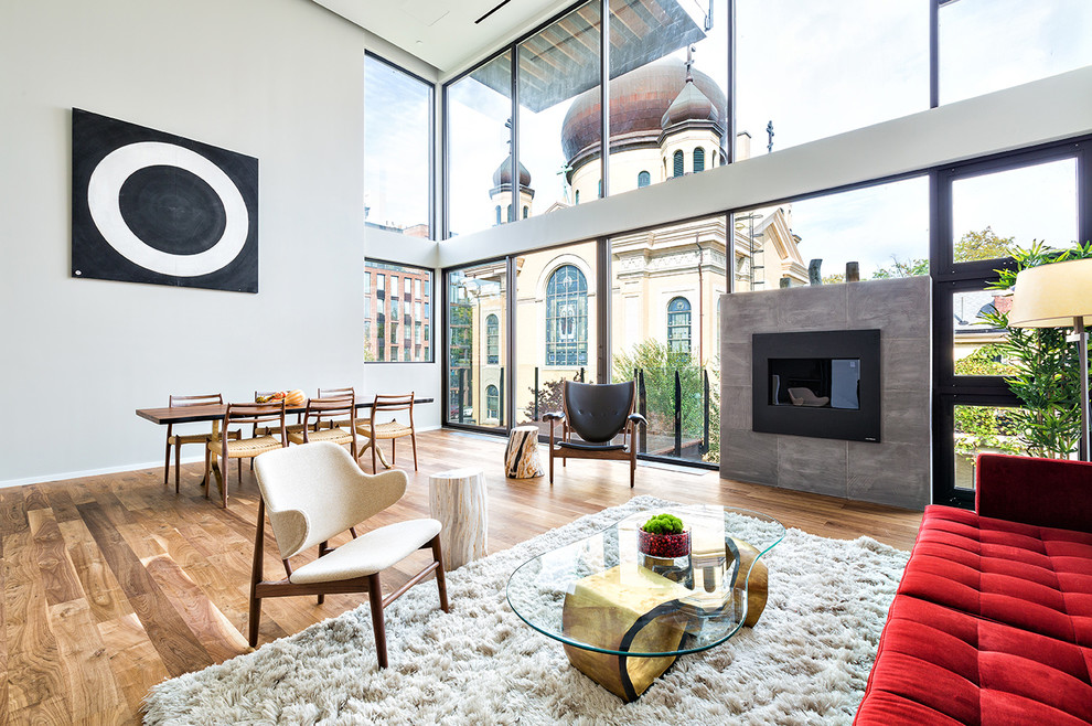 Example of a large trendy open concept medium tone wood floor living room design in New York with a standard fireplace, a stone fireplace and gray walls