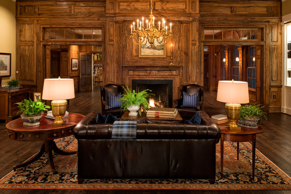 Пример оригинального дизайна: большая изолированная, парадная гостиная комната в классическом стиле с темным паркетным полом, стандартным камином, фасадом камина из дерева, бежевыми стенами, коричневым полом и коричневым диваном без телевизора
