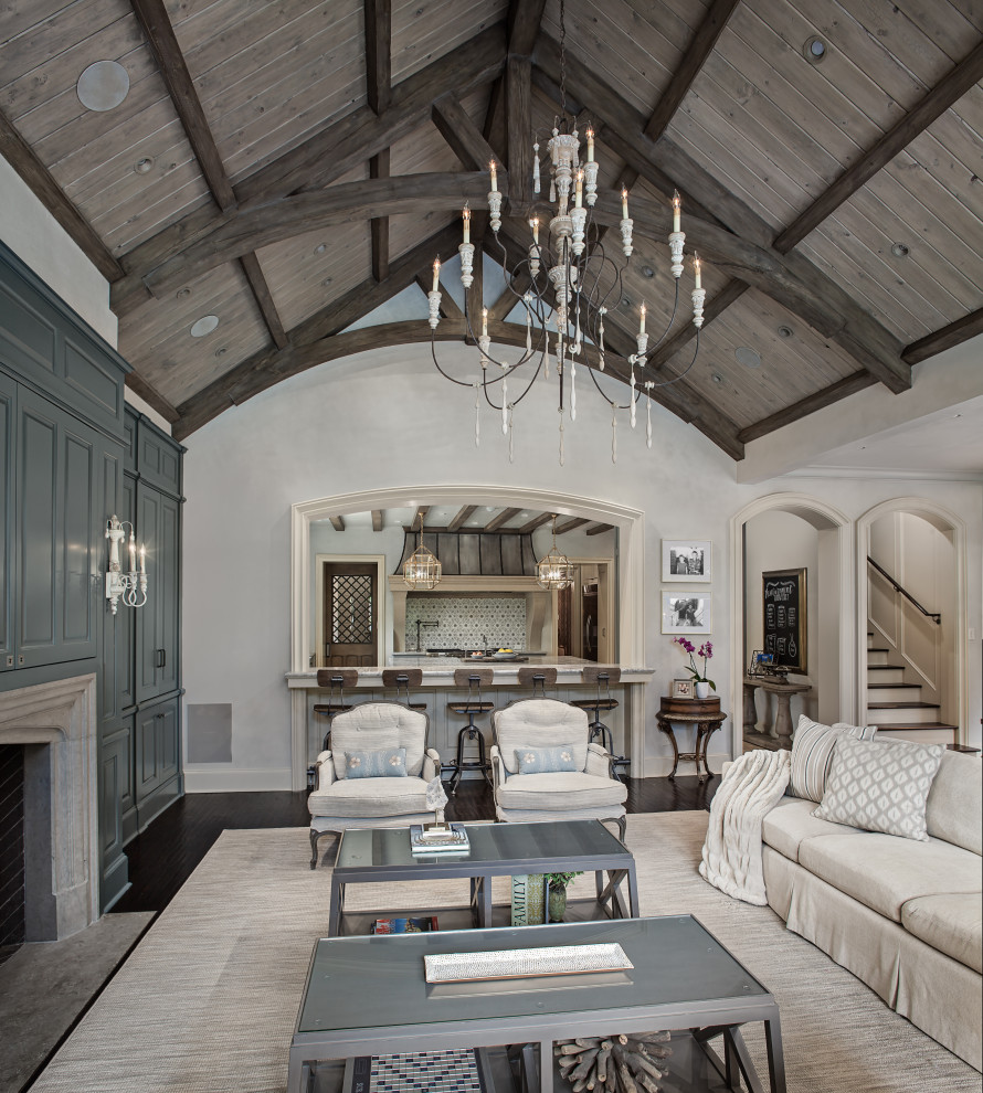 Inspiration for a medium sized traditional open plan living room in Houston with grey walls, dark hardwood flooring, a standard fireplace, a stone fireplace surround, a concealed tv and brown floors.